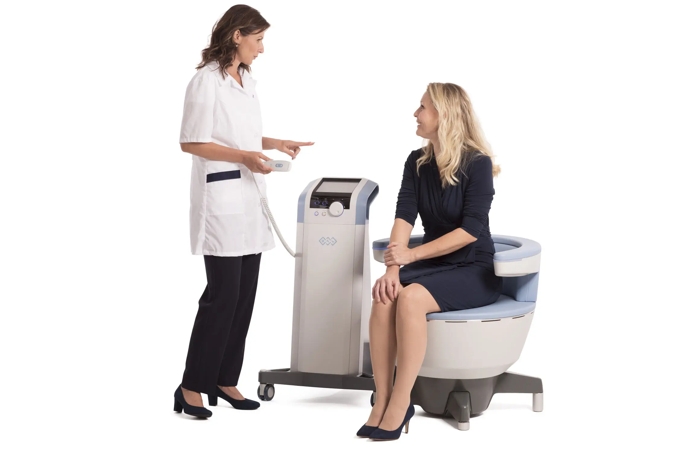 Aesthetician explaining Emsculpt treatment to a seated client.